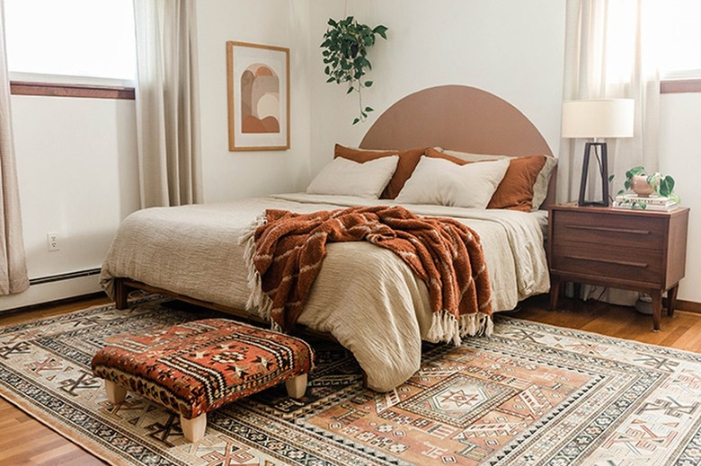 Vintage rug ottoman in a bedroom with neutral, beige, and brown accents