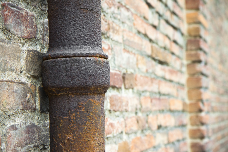 Detail of a pipe against a brick wall.