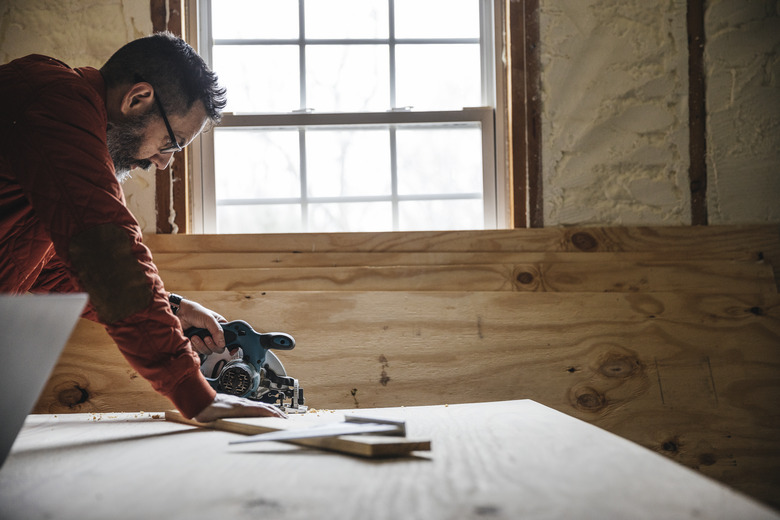 Carpenter cutting a piece of plywood.