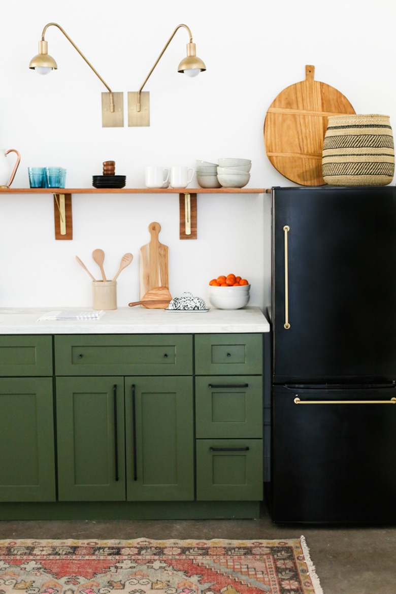 Brass wall sconces above open shelving for bohemian kitchen lighting