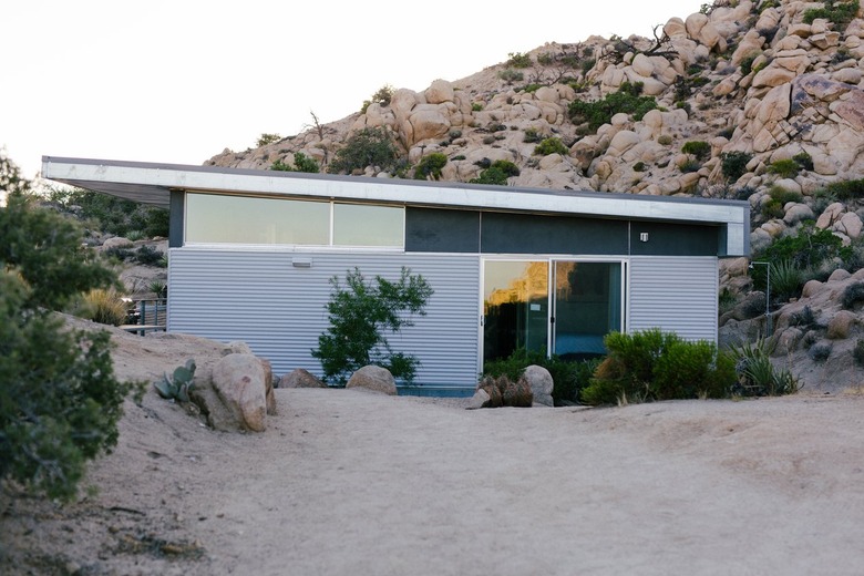 a pre-fab home with a glass and corrugated metal exterior