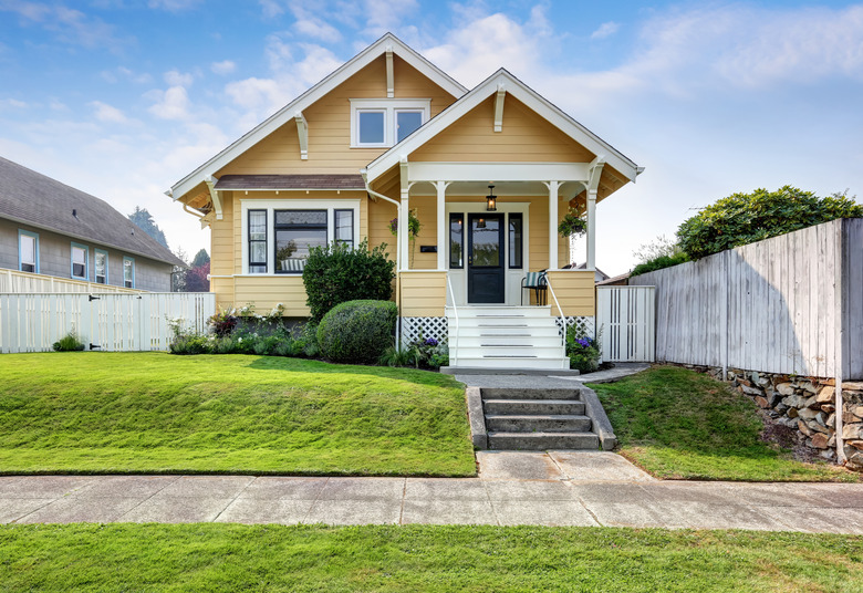 American craftsman home with yellow exterior paint.