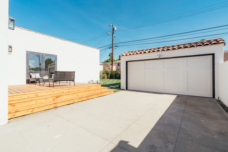 Wood deck next to driveway and garage.