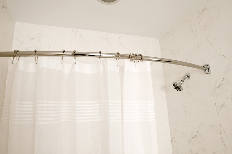 Curved shower rod, white bathroom and shower curtain.