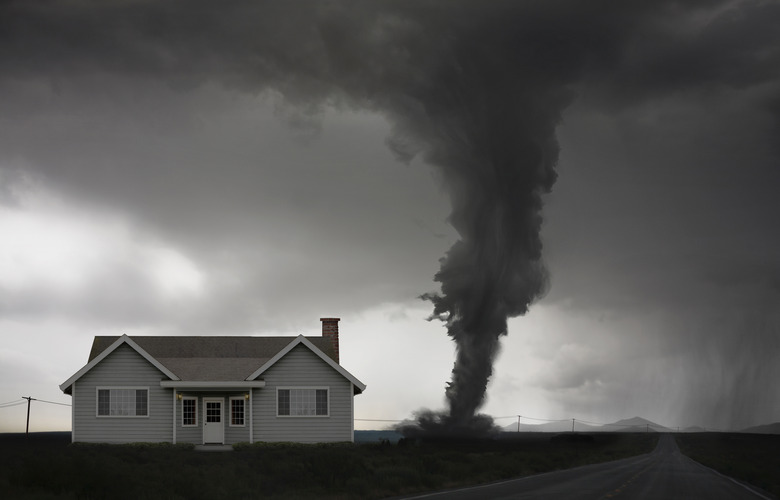 Tornado approaching house in rural landscape