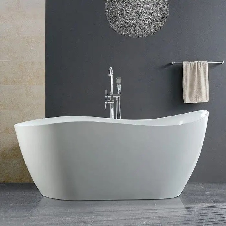 A curved garden tub in a gray bathroom