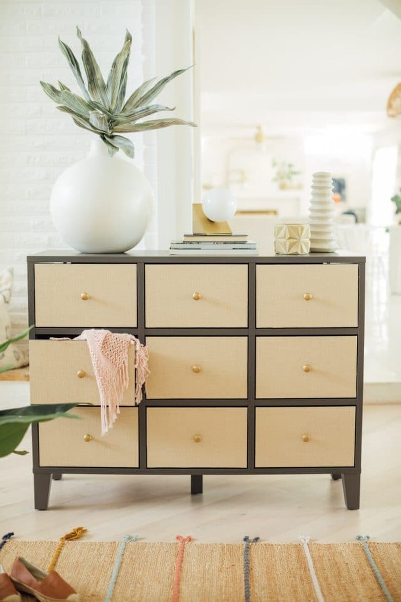 IKEA dresser with rattan drawers and large plant in white vase on top