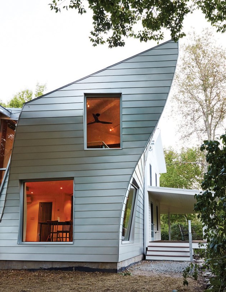 curved addition on farmhouse structure with steel siding