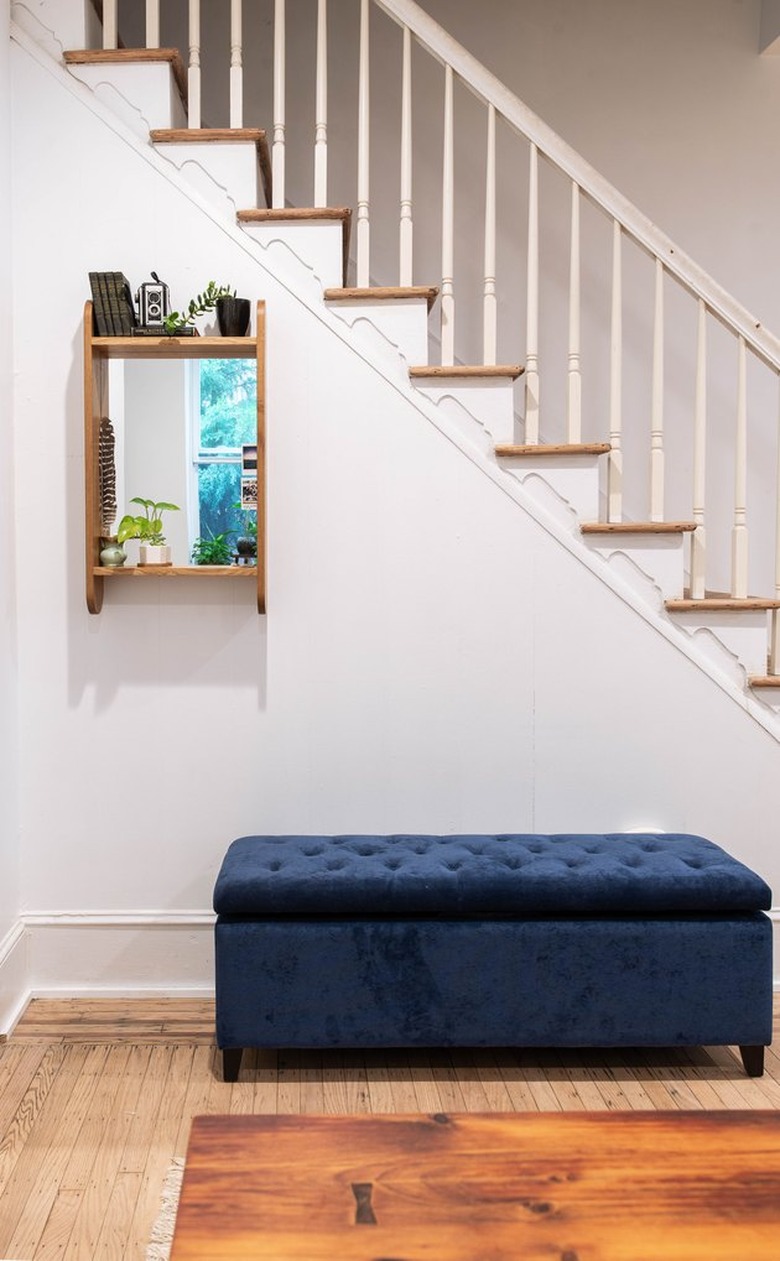 minimal entryway with oak mirror and blue velvet storage bench