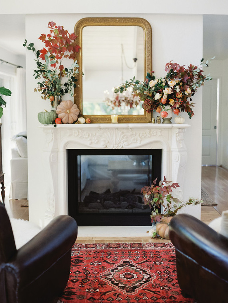 fall-inspired mantel decor with seasonal flowers and pumpkins