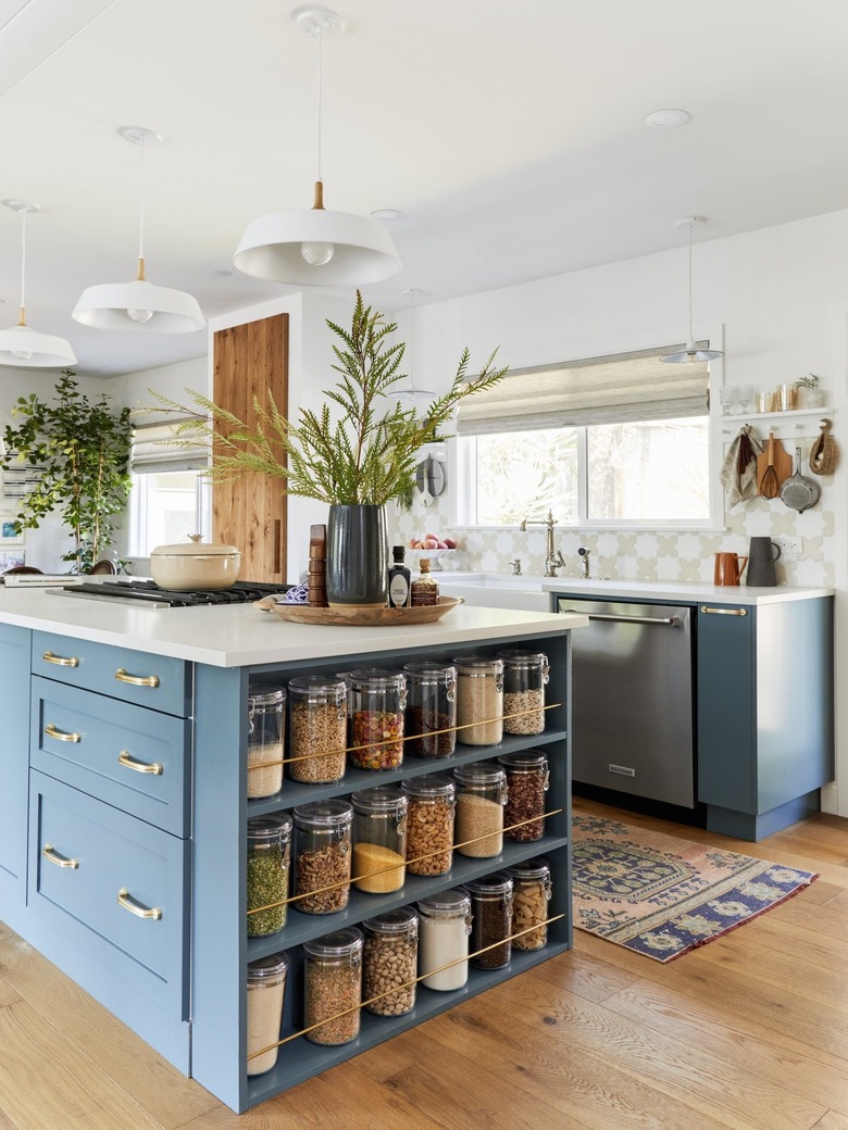 blue kitchen island with glass canisters stored at end