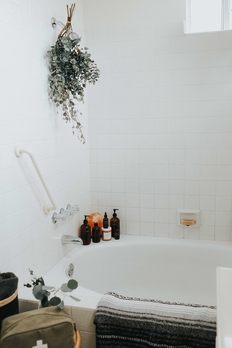 spa bathroom ideas with bundle of dried eucalyptus hanging from the showerhead