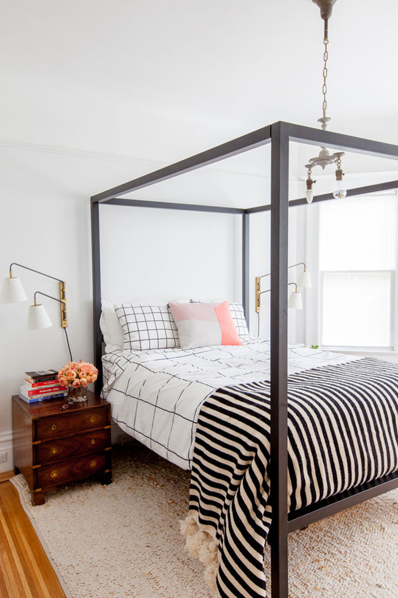 guest bedroom decorating idea with four poster canopy bed and patterned bedding