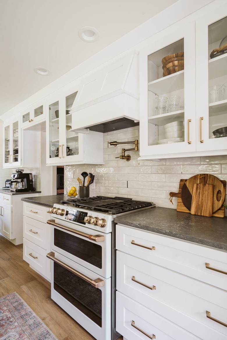 white cabinets with brass pulls and white stove