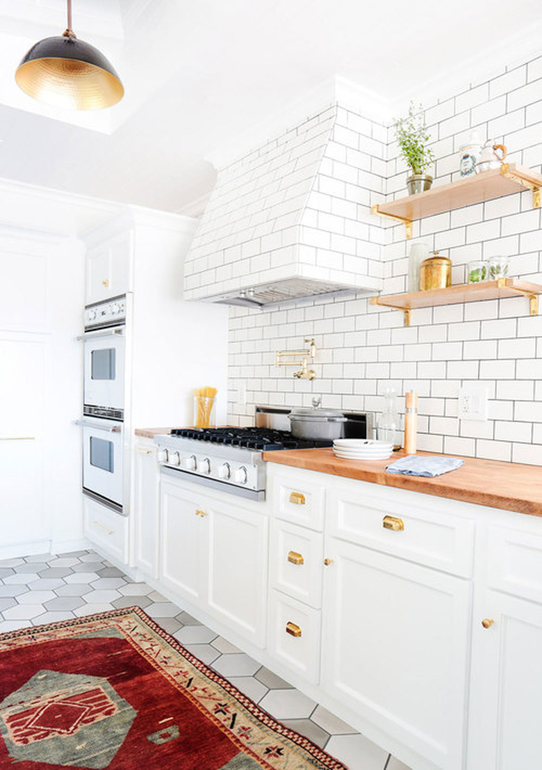 white kitchen cabinet idea with white subway tile and area rug