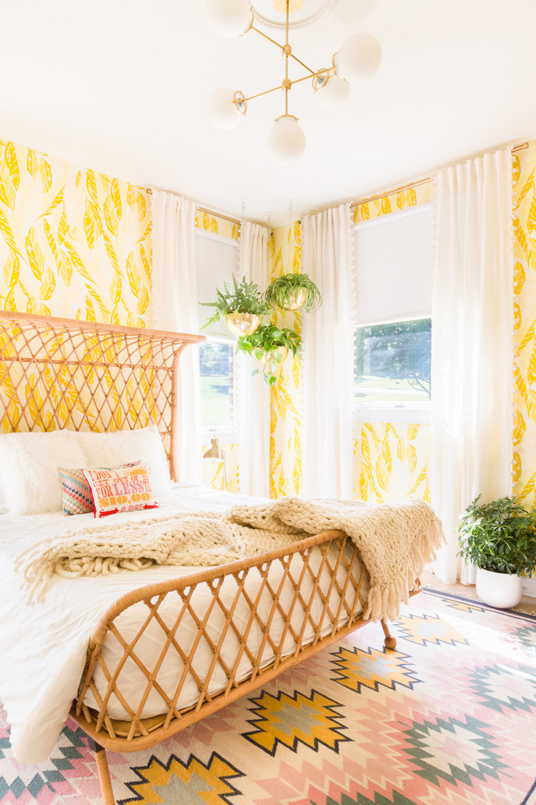 bedroom with yellow wallpaper and woven rattan bed