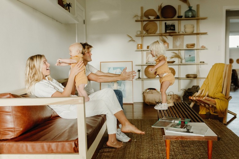 Parents playing with their young children in boho living room