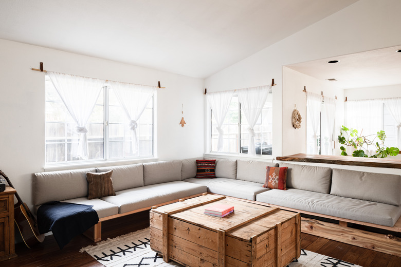 Living room with skylights, long gray sofa and plants