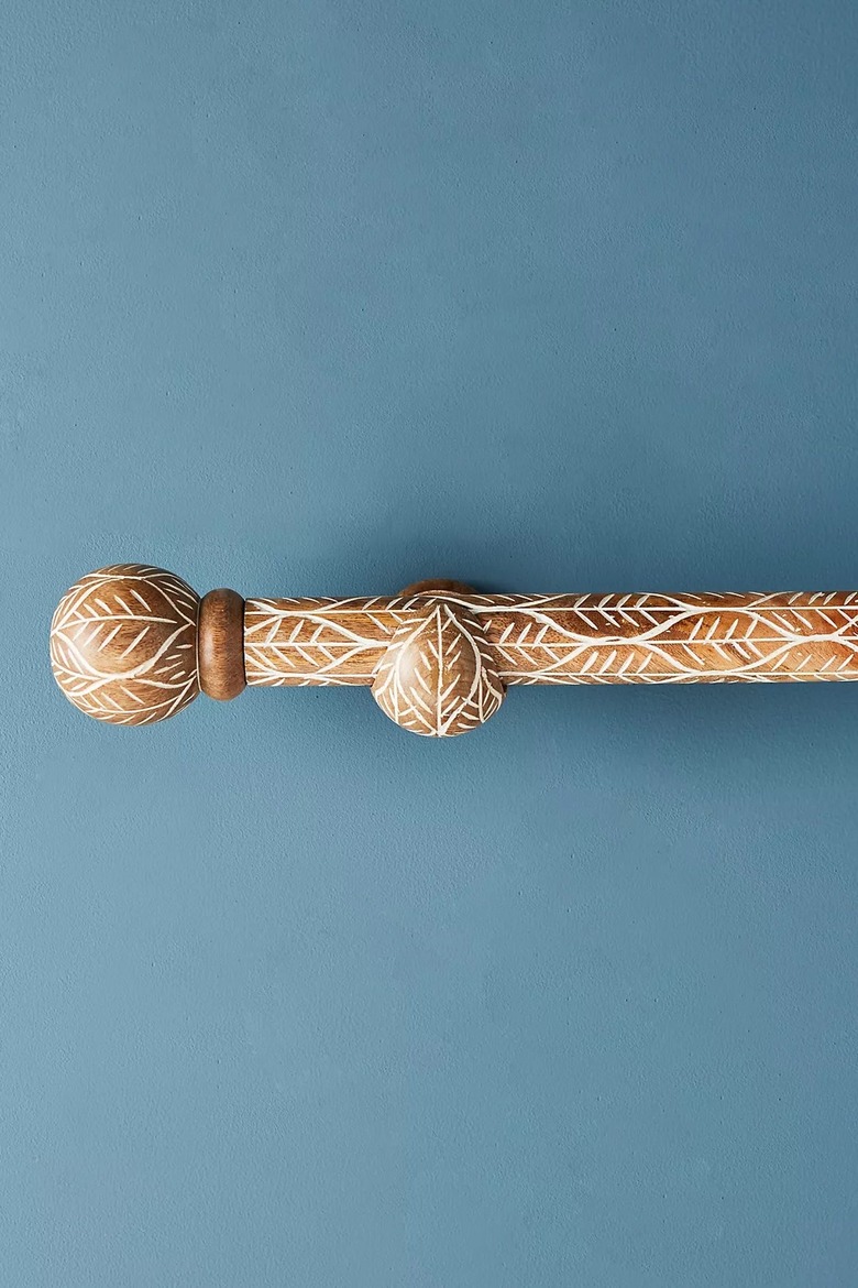 A twig-etched wooden curtain rod