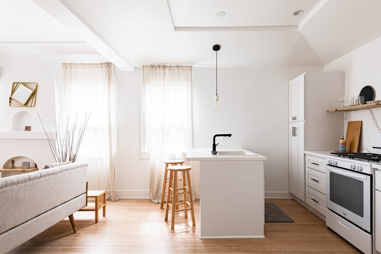 A white minimalist kitchen with an island sink