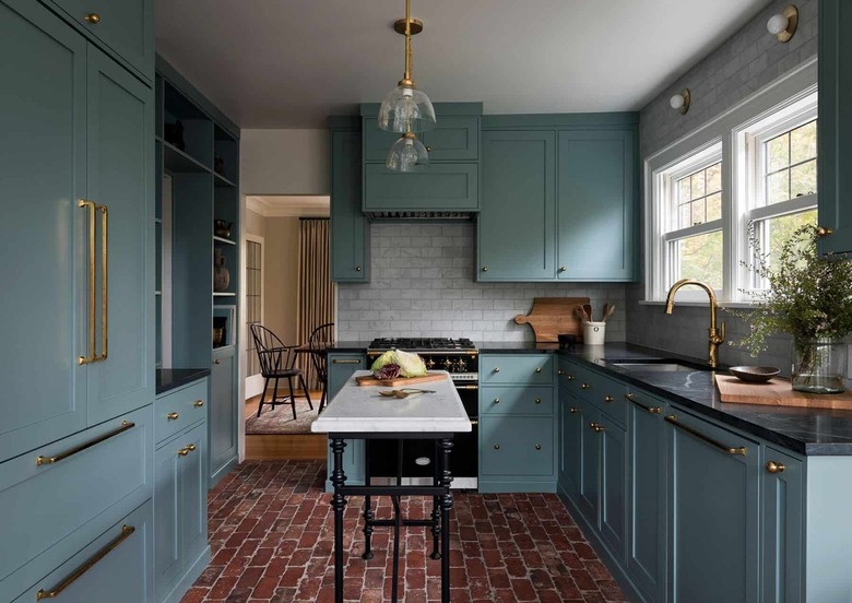 blue kitchen with black countertops and marble island