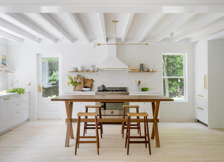 White kitchen design with rustic table and stools