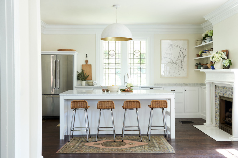 White kitchen design with dome shaped pendant and bar seating