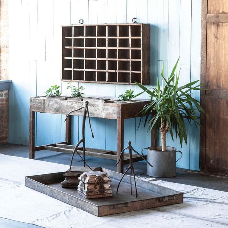 wood wall cubby above wood table and plant in metal pot