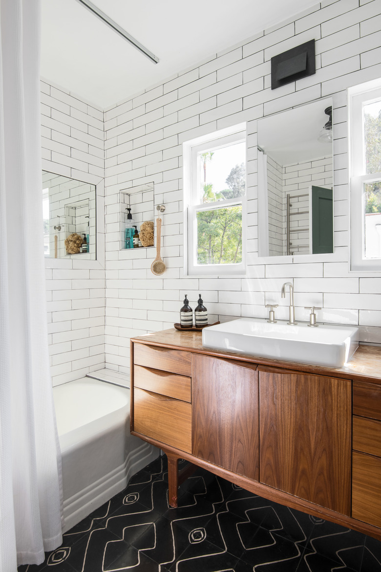 wood bathroom vanity cabinet, sink, shower and subway tile walls throughout