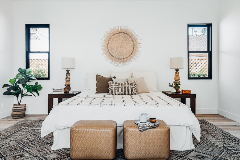 Bedroom with boho decor and basket hanging over bed.