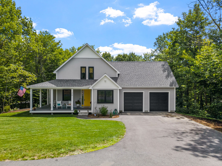 Modern custom new England colonial home with an American flag on a sunny day