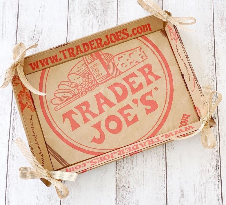 Trader Joe's cardboard box with the logo on a white wooden surface.