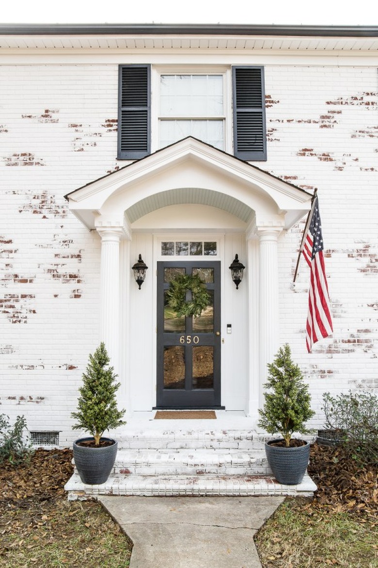 Traditional brick home in limewash paint with American flag