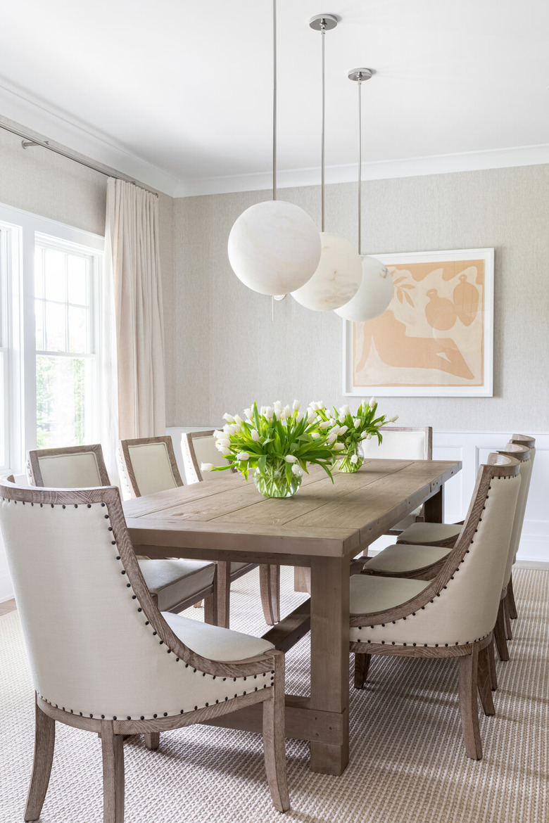 white traditional dining room with wooden table and globe pendant lights