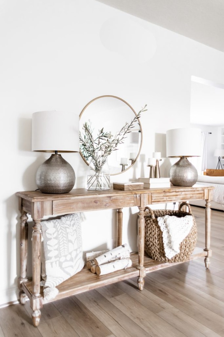 Traditional entryway table with round mirror and other traditional decor details