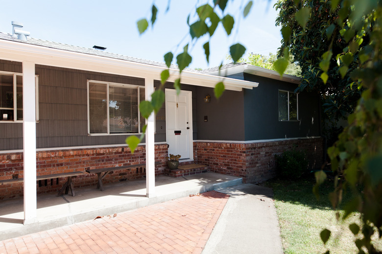 white traditional front doors on ranch style home with gray siding and brick exterior