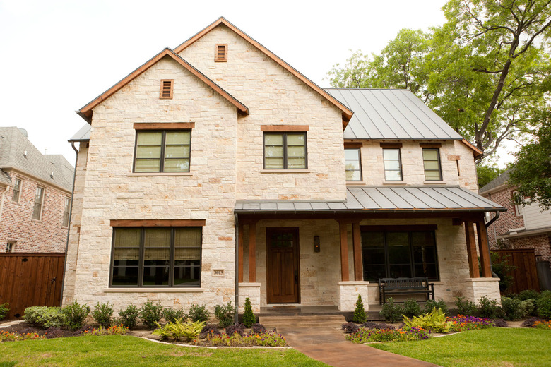 natural wood traditional front door on beige brick house