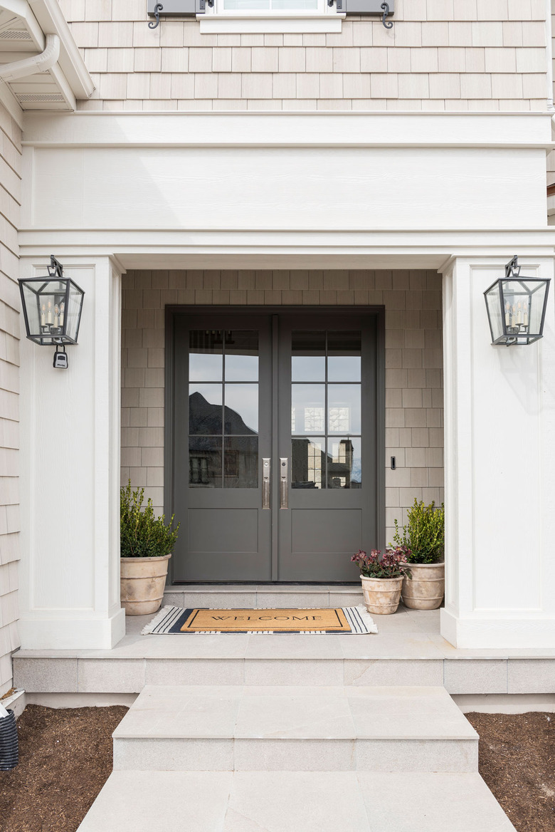 traditional home exterior idea with potted plants by the front door.