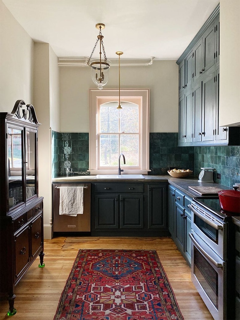 dark traditional kitchen with vintage rug and green tile backsplash