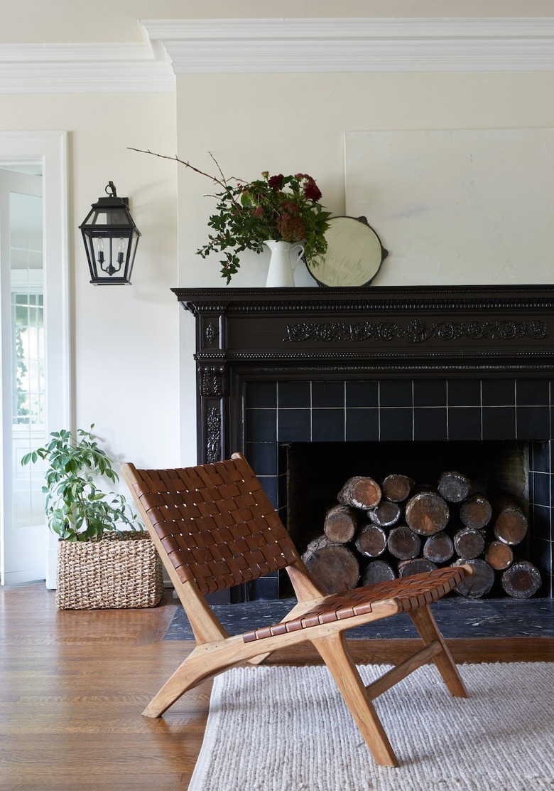 traditional mantel decor with ornate black tiled fireplace and wood side chair