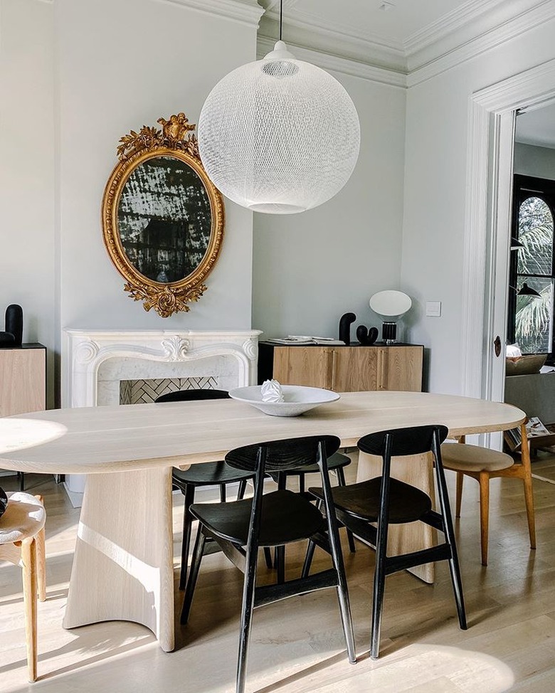 traditional mantel decor in dining room with white pendant light and ornate gold mirror