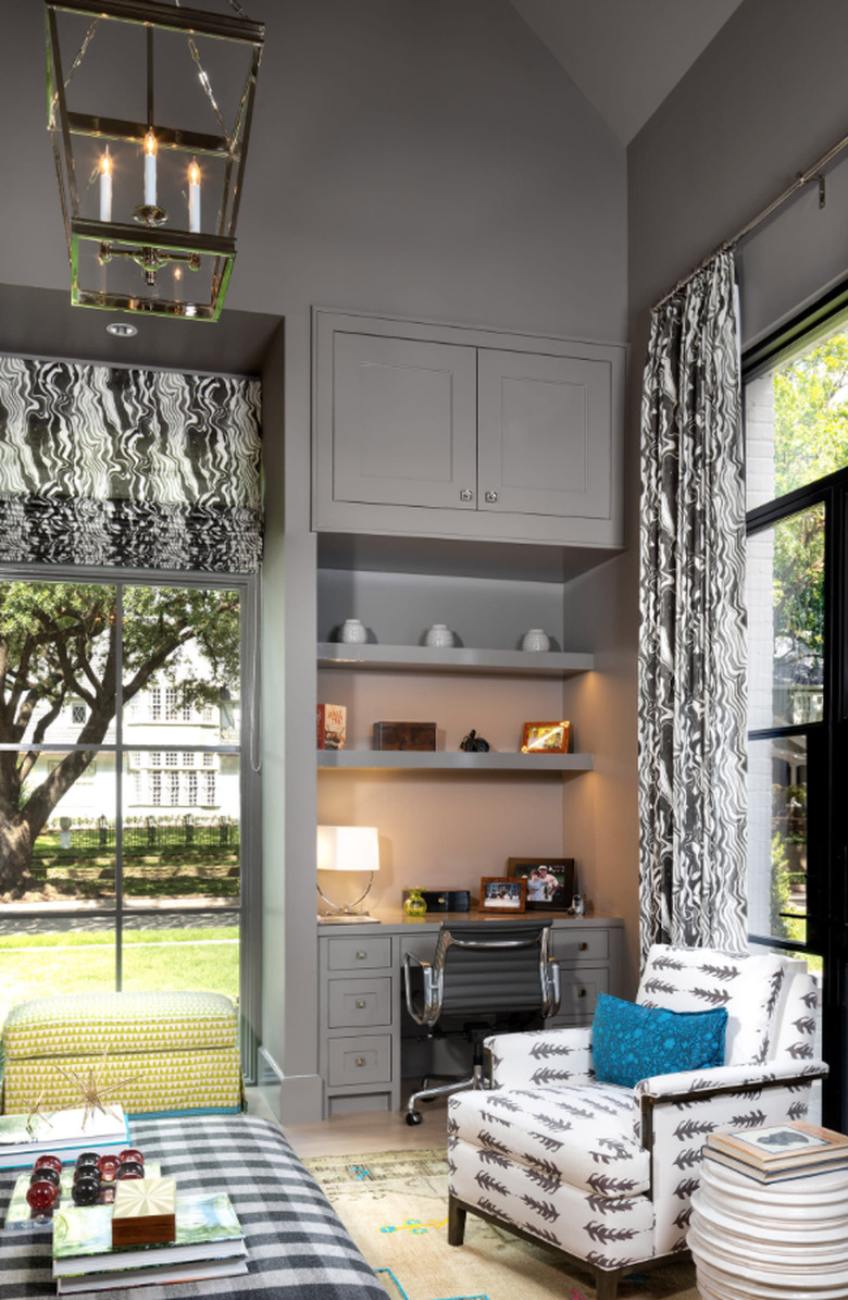 transitional family room with gray walls and ceilings, black and white checked ottoman, patterned side chair.