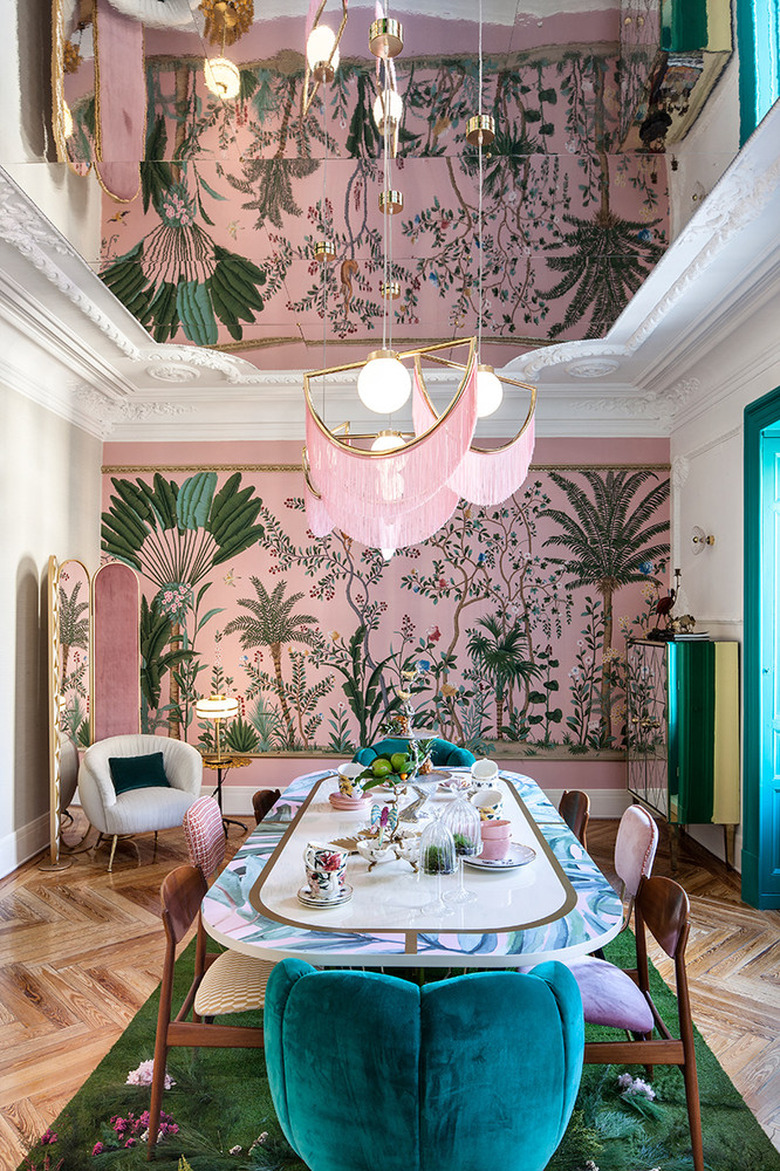 chinoiserie wallpaper in glam dining room with pink-fringed pendant lights