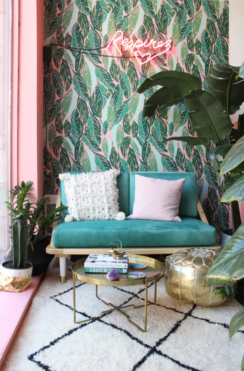 tropical living room with neon sign and palm leaf wallpaper