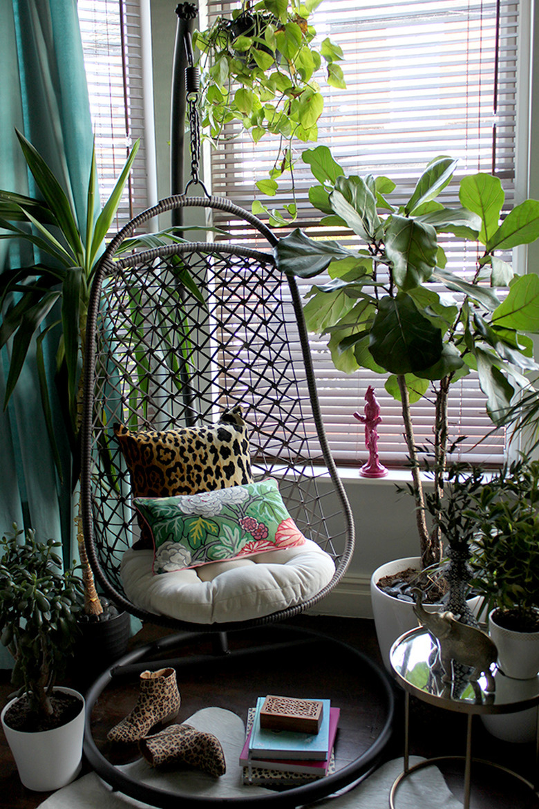 tropical living room with hanging chair and animal print throw pillow