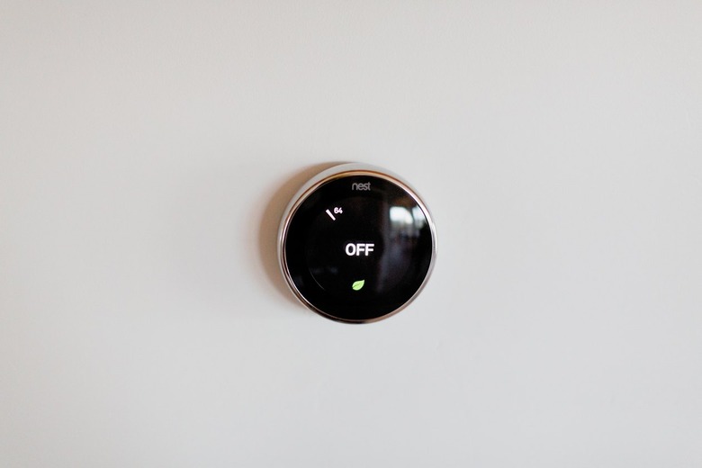 A Nest thermostat on a white wall.