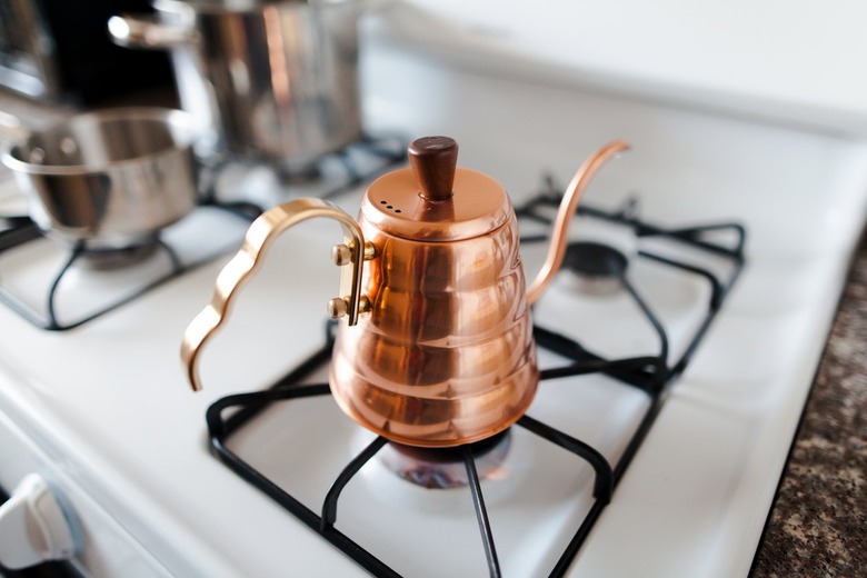 White gas stove with copper kettle