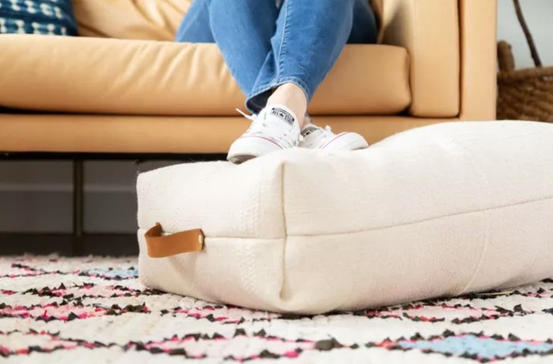 Floor pillow, rug, couch.