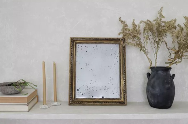 Antiqued mirror, vase, candles.