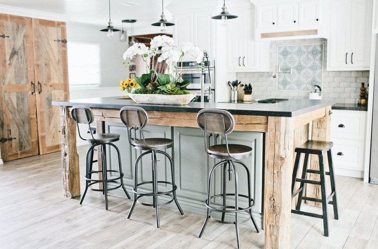 rustic wood and light green two-tier kitchen island with industrial bar stools